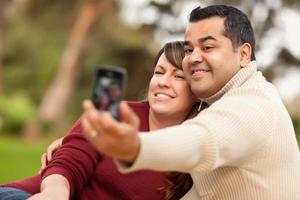 casal atraente de raça mista tirando autorretratos foto