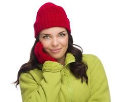 mulher de raça mista sorridente usando luvas e chapéu de inverno foto