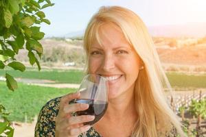 bela jovem adulta desfrutando de um copo de degustação de vinhos no vinhedo foto