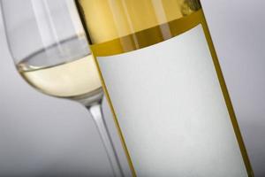 copo de vinho e garrafa com rótulo em branco pronto para gráfico e texto. foto