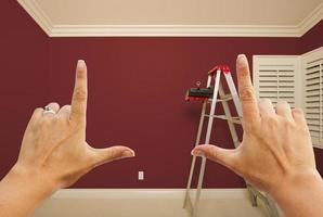 mãos emoldurando o interior da parede pintada de vermelho escuro foto