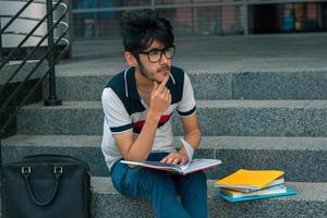 bonito estudante taciturno senta-se com livros foto