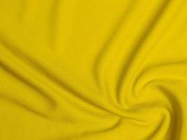 textura de tecido de veludo amarelo usada como plano de fundo. fundo de tecido amarelo vazio de material têxtil macio e liso. há espaço para texto foto