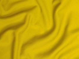 textura de tecido de veludo amarelo usada como plano de fundo. fundo de tecido amarelo vazio de material têxtil macio e liso. há espaço para texto foto