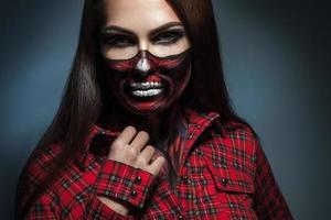 retrato horizontal de menina adulta com arte de rosto assustador para a noite de halloween foto