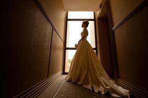 retrato de silhueta da jovem noiva loira em vestido de noiva foto