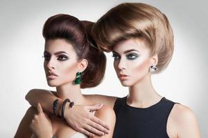 retrato aproximado de duas mulheres da moda de beleza com penteado de volume criativo e boa maquiagem foto