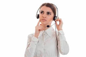 jovem morena pensativa chama mulher trabalhadora de escritório com fones de ouvido e microfone isolado no fundo branco foto
