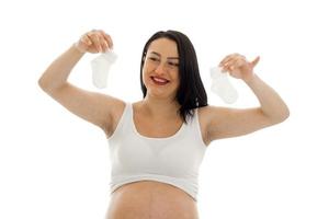 jovem mulher grávida sorridente em uma camiseta branca, levantou as mãos e sorrindo foto