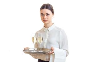 bela jovem garçonete segurando copos de vinho em uma bandeja que foto