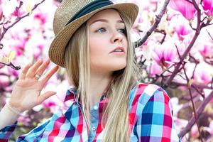 mulher loira adulta jovem séria com flores olhando para longe foto