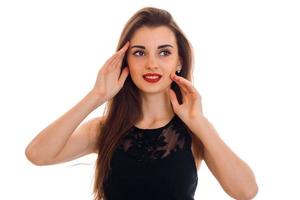 feche o retrato de uma jovem elegante com lábios vermelhos em vestido preto olhando para longe isolado no fundo branco foto