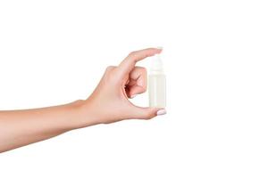 mão feminina segurando o frasco de creme de loção isolado. garota dá produtos cosméticos de tubo em fundo branco foto