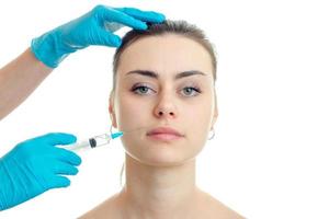 cosmetologista em luvas azuis fazendo injeções faciais em uma jovem foto