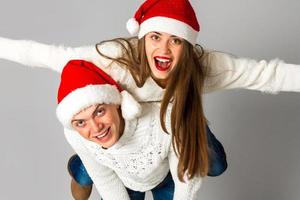casal apaixonado comemora o natal com chapéu de papai noel foto