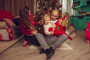 família jovem feliz com filha comemora o ano novo e o natal foto