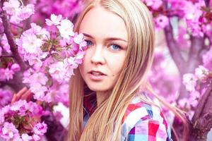 modelo de moda jovem em flores desabrochando rosa foto