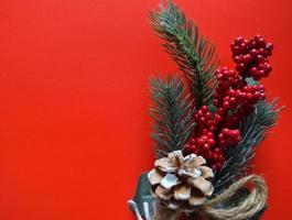 Decoração de Natal. galho de árvore do abeto fresco decorado contra fundo de cor vermelha, vista de cima, copie o espaço foto
