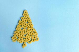 árvore de natal feita de macarrão em um fundo azul foto