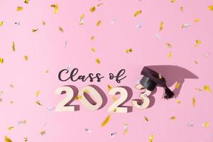 conceito de classe de 2023. números 2023 com boné graduado preto sobre fundo colorido foto