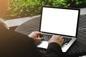 foco seletivo da mão do empresário tocando o botão no teclado do laptop. homem usando notebook de computador com tela em branco. homem trabalhando no computador portátil com as duas mãos. fundo do conceito de negócio. foto