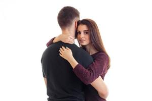 abraços de linda jovem com um cara no estúdio isolado em um fundo branco foto