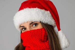 menina de chapéu de papai noel e lenço vermelho foto