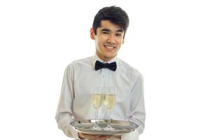 retrato horizontal do belo garçom sorridente com copos de vinho isolados em um fundo branco foto