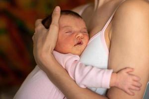 garotinha dorme nas mãos da mãe foto