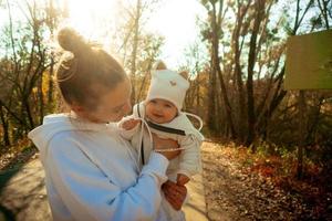 bela jovem mãe com bebê no outono foto