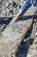 trabalhador da construção civil piscina trabalhando com flutuador de madeira em concreto molhado foto