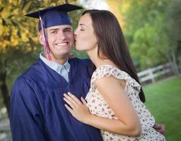 graduado masculino em boné e vestido e menina comemoram foto