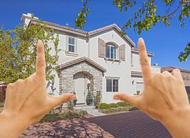 mãos femininas emoldurando linda casa foto