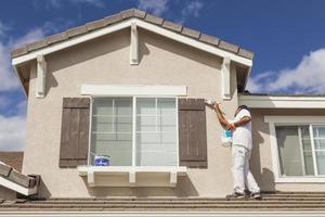 pintor de casa pintando a guarnição e persianas de casa foto