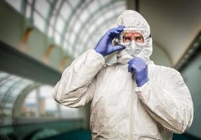 homem com expressão intensa vestindo roupas de proteção hazmat dentro do prédio foto