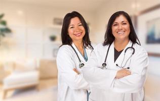 mulheres hispânicas médicas ou enfermeiras em pé em um escritório foto