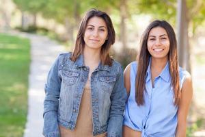 retrato de duas lindas irmãs gêmeas étnicas ao ar livre. foto