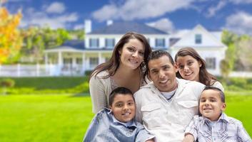 jovem família hispânica na frente de sua nova casa foto