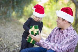 pai dando presente de natal para filha foto