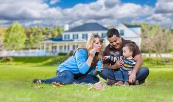 feliz família étnica de raça mista brincando com bolhas no jardim da frente foto