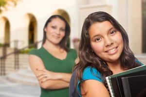 orgulhosa mãe hispânica e filha no campus da escola foto