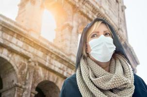 jovem usando máscara facial caminha perto do coliseu romano em roma, itália foto