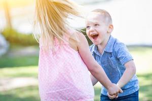 jovem irmão e irmã brincando juntos no parque foto