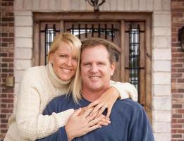 casal jovem feliz na frente da porta da casa foto