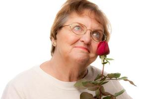 mulher sênior atraente com rosa vermelha foto