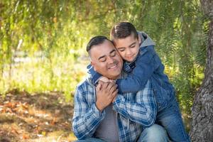 retrato de pai de raça mista e filho se divertindo ao ar livre foto