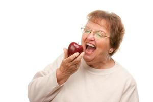 mulher sênior atraente com maçã foto