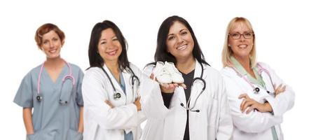 médica ou enfermeira hispânica com sapatos de bebê e equipe de apoio atrás foto