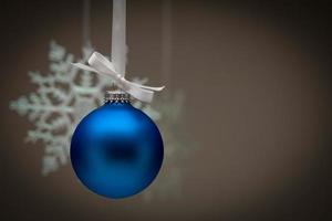 floco de neve e enfeite de natal azul contra fundo escuro foto