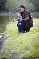 feliz jovem étnico pai e filho pescando foto